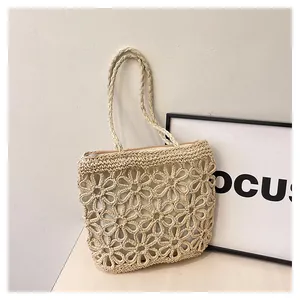 Macro view of delicate hollow floral pattern on a beige woven shopping tote bag.