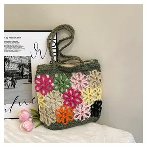 Detailed close-up of a handmade crochet tote bag featuring vibrant colorful flower patterns