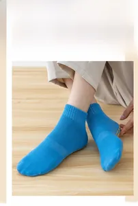 Blue anti-slip trampoline socks with PVC dots shown on wooden floor