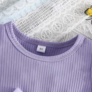 Close-up detail of purple ribbed princess dress neckline showing size 80 label for babies
