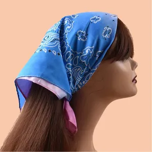 Nahaufnahme eines Bandanas mit blau-rosa Farbverlauf und Paisleymuster als Kopftuch