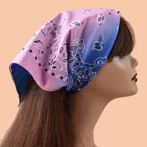 Detailansicht eines rosa-blauen Paisley-Schals, der als Stirnband getragen wird.