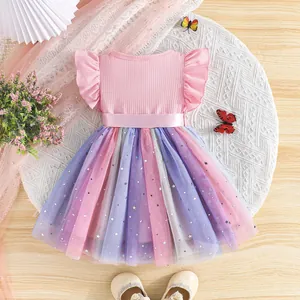 Close-up of pink princess dress with star moon patterned rainbow mesh skirt and belt.