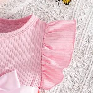 Close-up of pink ribbed princess dress with ruffle sleeves and elegant satin bow belt
