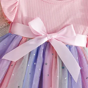 Detail of pink satin bow and colorful mesh skirt with star and moon sequins.