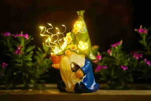 Outdoor solar garden gnome statue featuring glowing LED flowers and warm night light.