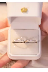 Detailed macro view of Mobius 999 silver couple rings presented in an elegant gift box