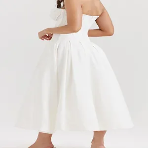 Detailed side view of a white strapless A-line dress featuring structured pleated waist.