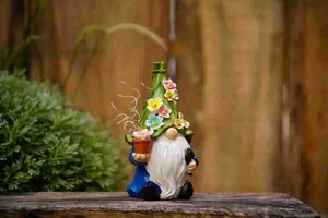 Close-up of a decorative solar garden gnome figurine with a colorful floral hat on wood