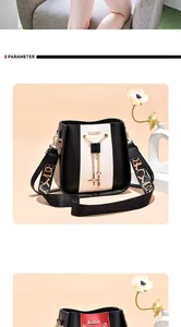 Trendy black and white bucket bag detail featuring a wide patterned strap and golden pendant