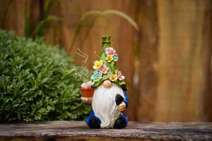 Detailed view of a garden gnome figurine with colorful flower hat decoration outdoors