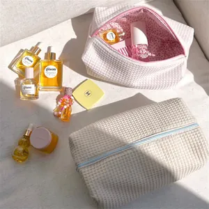 Large capacity waffle texture travel makeup bag with zipper and floral lining.
