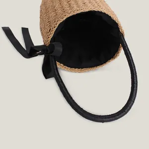 Handmade cylindrical straw woven bucket bag with black ribbon bow for summer beach