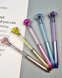 Close-up detail of stylish ballpoint pens with large diamond tops and crystal-filled barrels