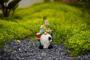 Detailed view of a garden gnome solar ornament decorated with flowers on a mossy garden pathway