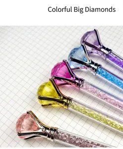 Close-up of five colorful ballpoint pens with large diamond-shaped tops on grid paper.