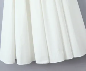 Detailed macro view showing the crisp white pleated hem of an A-line cotton summer dress