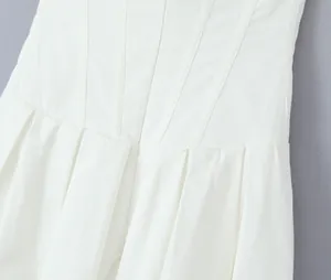 Close-up detail of a white dress bodice with structured waist pleats and seams