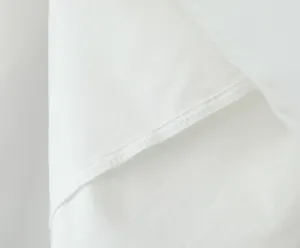 Macro close-up shot showing high-quality stitching and white fabric texture of a dress