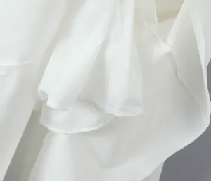 Detailed close-up showing white layered tulle and pleated hem on this elegant summer dress
