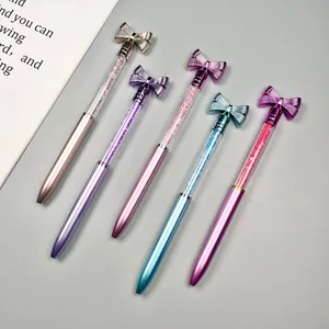 Macro view of five multicolored crystal ballpoint pens with decorative bow toppers
