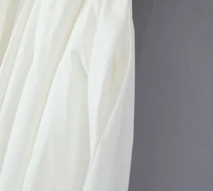 Detailed macro view of side pocket on elegant white off-shoulder pleated A-line dress