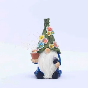 Solar garden gnome statue with flower hat and tools for outdoor yard landscaping decoration