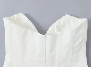 Macro view showing the sweetheart neckline and invisible zipper detail of the white corset top.