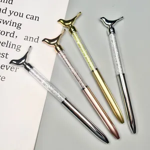 Detail of four elegant ballpoint pens with bird toppers and sparkling crystal barrels