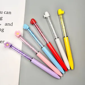 Detail of six colorful plastic ballpoint pens with crystal fillings and flower toppers