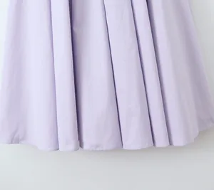 Close-up detail of lavender pleated A-line dress hem showing smooth fabric texture