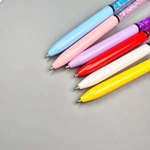 Detailed view of colorful crystal-filled ballpoint pens on a grey background
