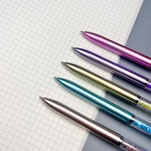Set of 5 metallic ballpoint pens with sparkling crystal accents on a grid paper