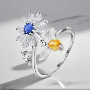 Close-up of adjustable silver-plated bee and flower ring with sparkling zircons
