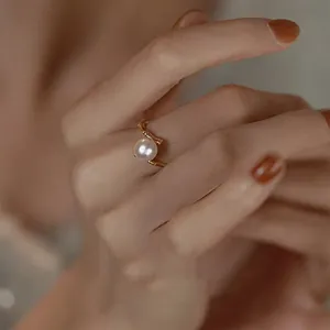 Detailed shot of a French-style gold bamboo ring with a single white pearl.