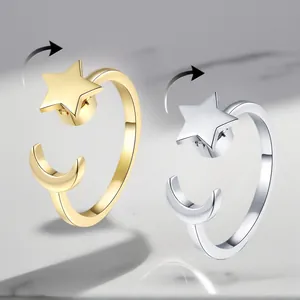 Detail of gold and silver adjustable rotating rings featuring star and moon charms
