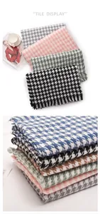 Stack of colorful houndstooth pattern scarves showcasing soft texture and fringed edges.