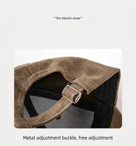 Close-up view of adjustable metal buckle on a minimalist brown suede baseball cap.