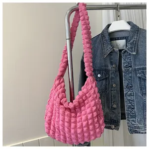 Stylish pink bubble texture cloud shoulder bag displayed next to a casual denim jacket