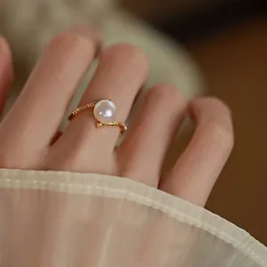 Elegant French style bamboo joint ring with a lustrous white pearl on a finger.