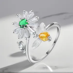 Close-up detail of the daisy and bee motifs on an adjustable silver-toned zircon ring