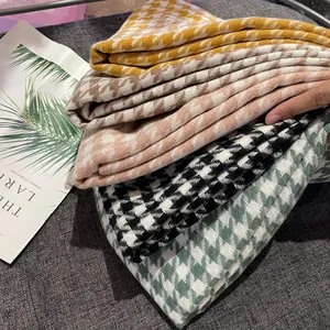 Detailed view of stacked multi-colored houndstooth winter scarves with soft texture