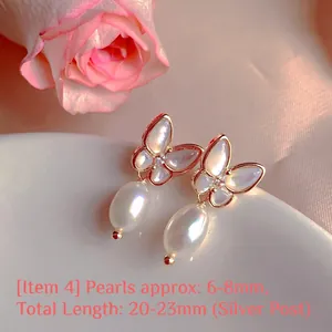Close-up detail of butterfly-shaped earrings featuring natural pearls and silver posts
