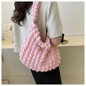 Detailed close-up of a pink bubble textured cloud shoulder bag being worn by a model