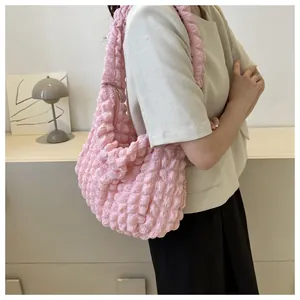 Pink bubble cloud shoulder bag with textured surface worn by a model