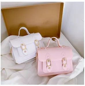 Detail of stylish pink and white jelly satchel bags with gold buckle accents for women