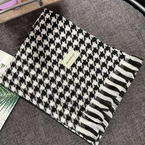 Detail showing the classic black and white houndstooth pattern and soft fringe edges