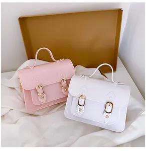 Detailed macro view of pink and white jelly Cambridge bags with elegant golden buckle accents