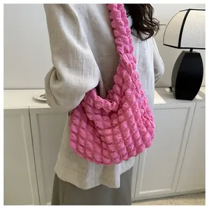 Detail view of the bright pink bubble cloud bag styled with a minimalist beige coat