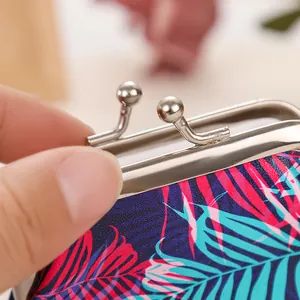 Detailed view of tropical palm leaf print coin purse with silver metal kiss-lock clasp